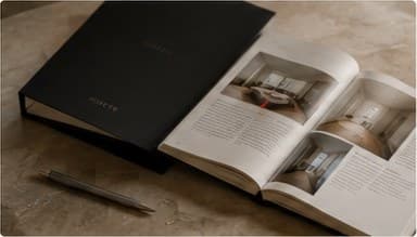 Раскрытый альбом с чертежами и фотографиями квартиры на столе